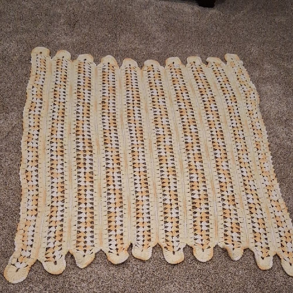 Handmade yellow and white crocheted‎ baby blanket with a scalloped edge